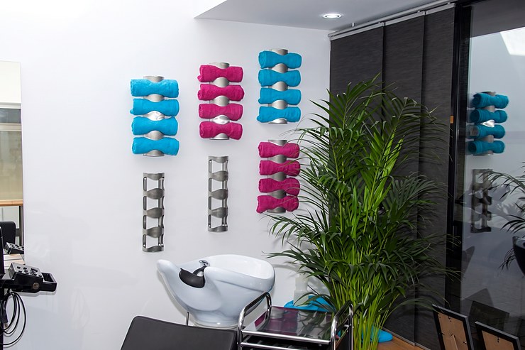 Waschplatz mit farbigen Handtuchregalen an der hellen Wand